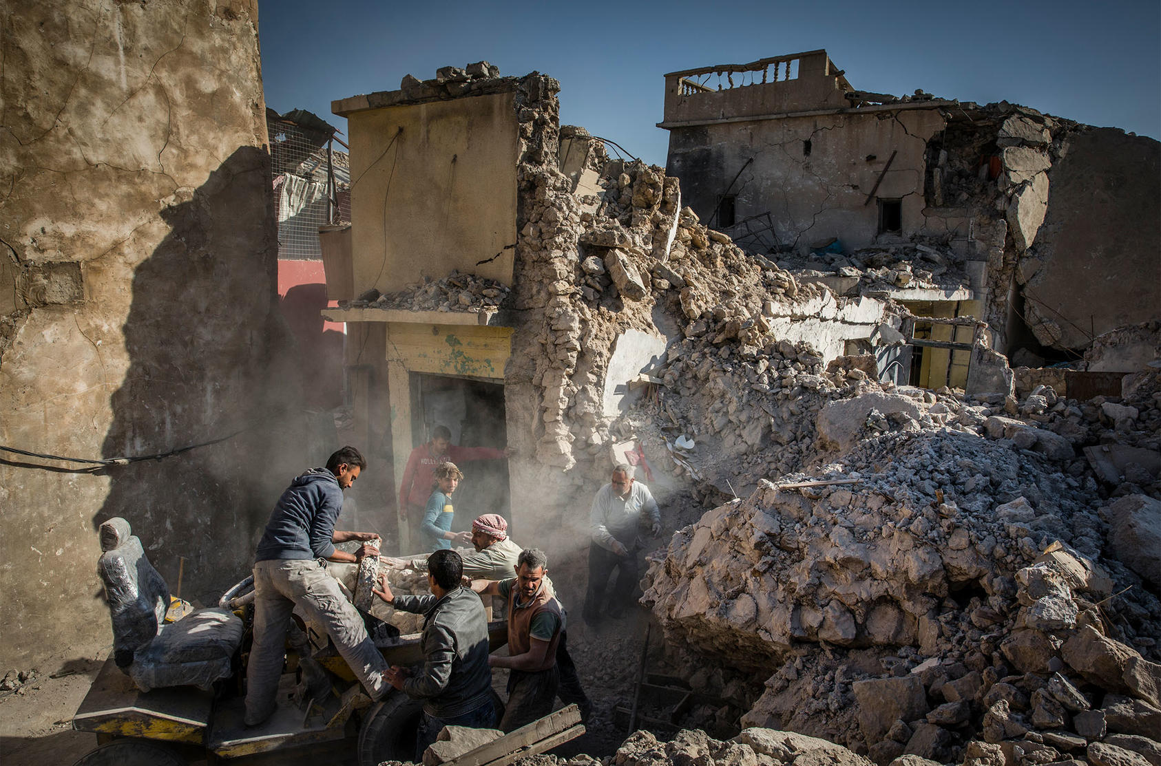 A family begins the arduous task of rebuilding its destroyed home in the heavily damaged Old City in west Mosul, Iraq, Dec. 4, 2017. (Ivor Prickett/The New York Times)