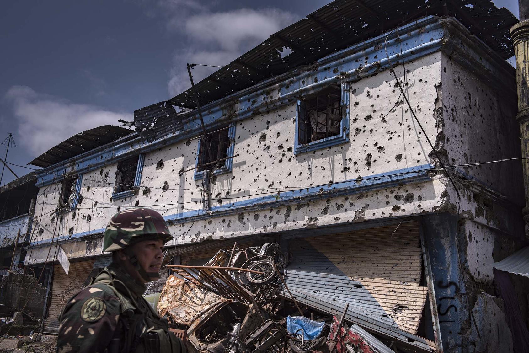 A government soldier outside a ruined building in Marawi, a city in the southern Philippines that was for months under the control of an affiliate of the Islamic State group, Aug. 30, 2017. (Jes Aznar/The New York Times)