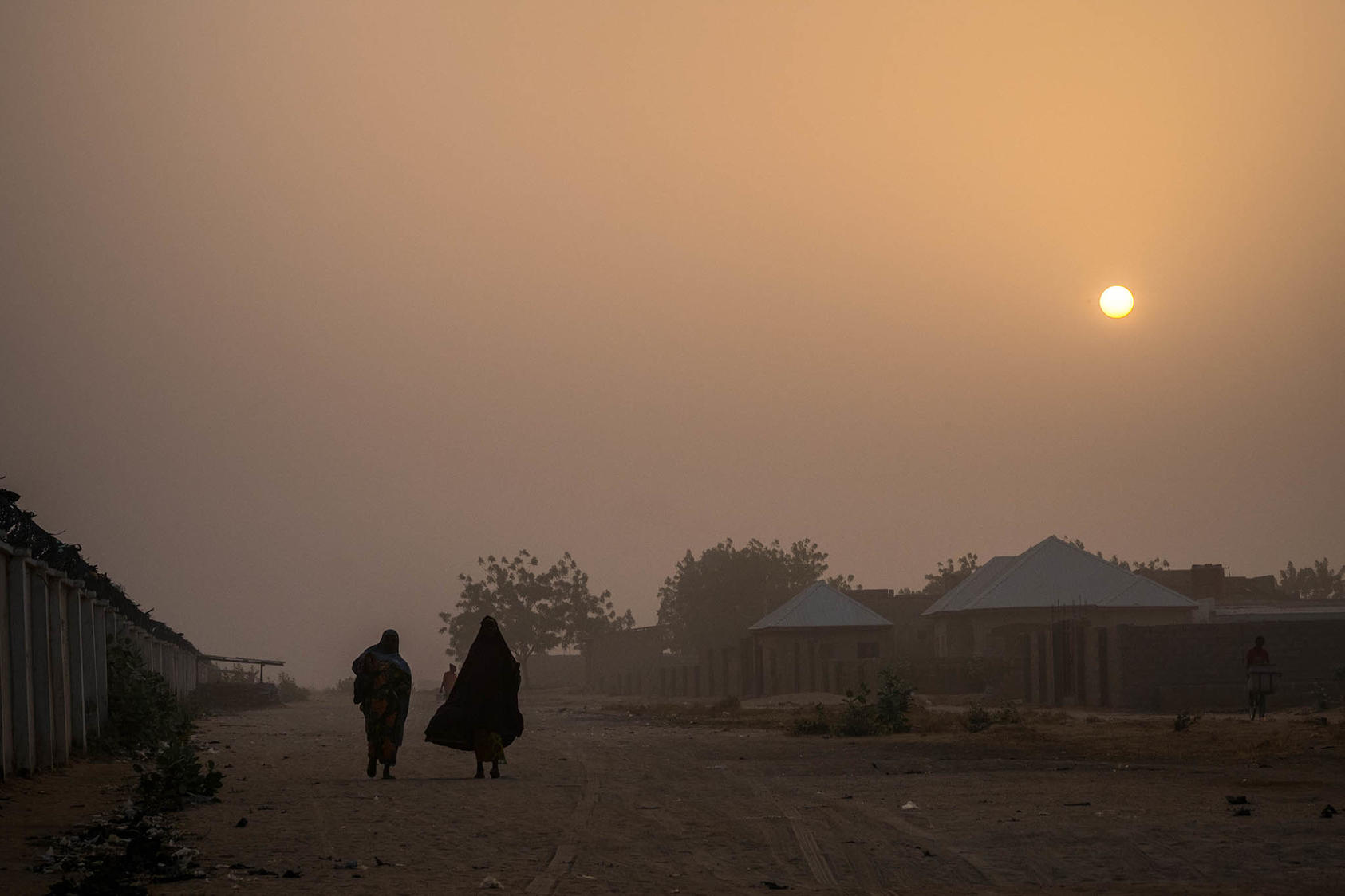 People walk through a refugee camp in Maiduguri, Nigeria, Feb. 17, 2017. (Ashley Gilbertson/The New York Times)